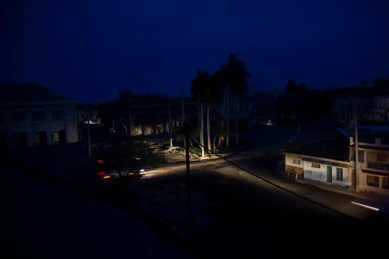 Vehicle headlights illuminate a street during a blackout triggered by Hurricane Ian in Havana early Wednesday.