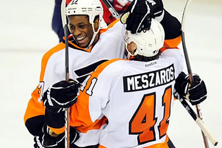 Right wing Wayne Simmonds celebrates his second period goal with Andrej Meszaros. (Nick Wass/AP Photo)