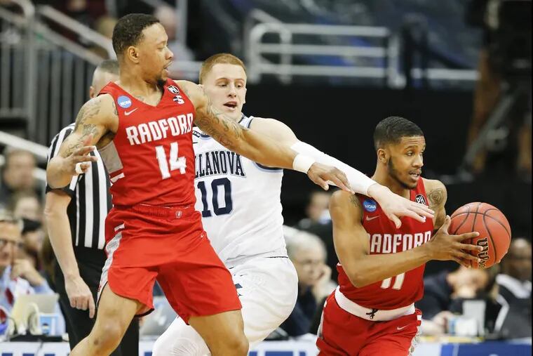 Villanova guard Donte DiVincenzo (center) gets sandwiched going after the basketball against Radford guard Travis Fields Jr., (right) and guard Justin Cousin during the first-half in the first round of the NCAA Men's Basketball Tournament on Thursday, March 15, 2018 at PPG Paints Arena in Pittsburgh.