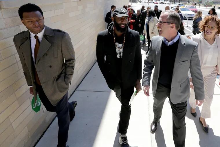 Will Allen (left) and Eagles safety Malcolm Jenkins (center) listen as Kevin Ring (right), founder of Families for Justice Reform, explains he is a Redskins fan as they take a tour in Philadelphia.