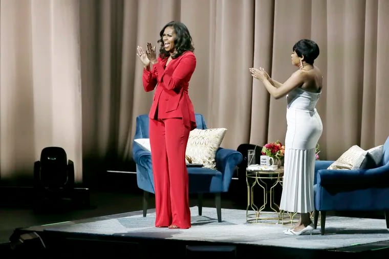 Michelle Obama greets the crowd during her Becoming: An Intimate Conversation with Michelle Obama tour, featuring moderator Phoebe Robinson at the Wells Fargo Center in Phila., Pa. on November 29, 2018.