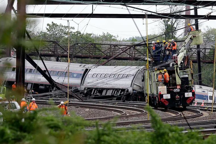 Emergency personnel on Wednesday, May 13, 2015, work at the scene of a deadly train derailment in Philadelphia. ( AP Photo / Mel Evans )