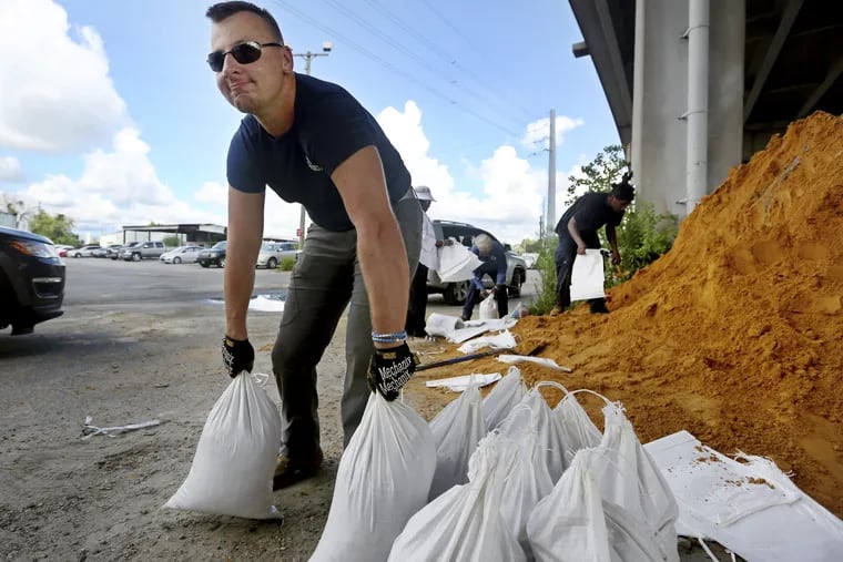 Kevin Orth loads sandbags into cars on Milford Street as he helps residents prepare for Hurricane Florence on Monday in Charleston, S.C.