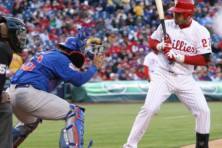 Cubs catcher Geovany Soto tries to track down a Paul Maholm wild pitch as the Phillies' Placido Polanco watches. Juan Pierre advanced to second on the play.