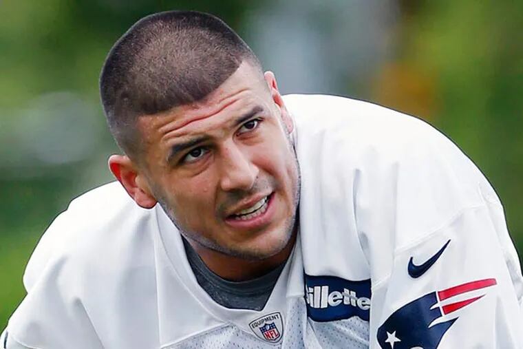 In this May 29, 2013, file photo, New England Patriots' Aaron Hernandez kneels on the field during NFL football practice in Foxborough, Mass. Hernandez is being sued in South Florida by a man claiming Hernandez shot him in the face after an argument at a strip club. The lawsuit comes as police in New England investigate Hernandez's possible connection to the death of a semipro player. (AP Photo/Michael Dwyer, File)