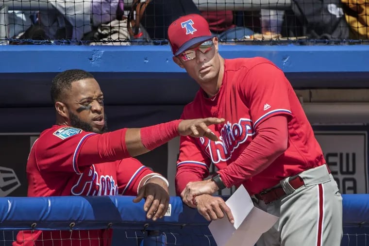 Philadelphia Phillies manager Gabe Kapler, right, talks things over with first baseman Carlos Santana, right, during a spring game.