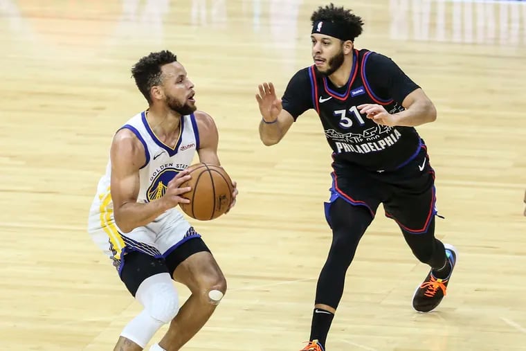 Sixers' Seth Curry guards his brother Warriors' point guard Stephen Curry during the fourth quarter at the Wells Fargo Center on Monday.