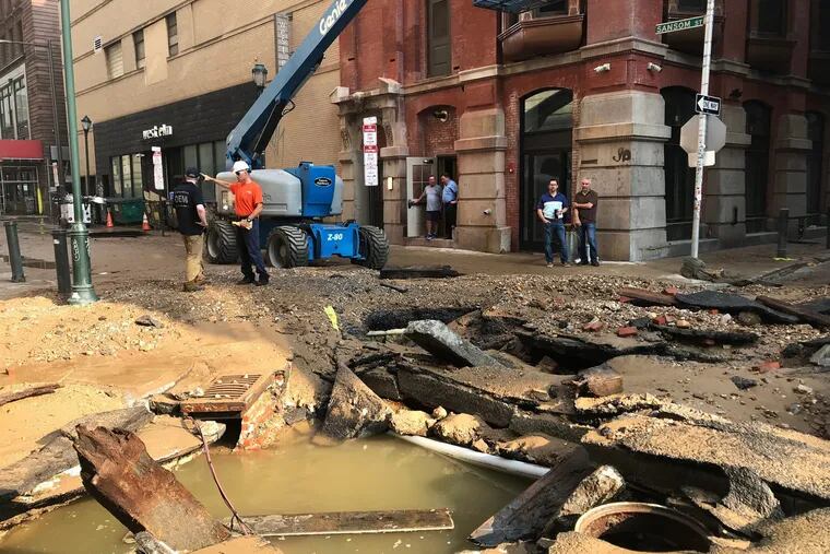 Philadelphia Water Department personnel work in Center City where a water main break occurred early Tuesday, July 3, 2018. The break happened before 4 a.m. Tuesday, and a number of center city streets have been closed.