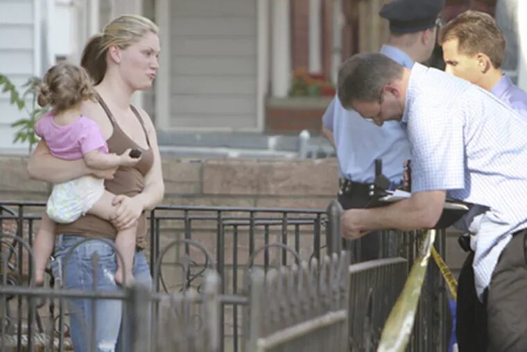 Britney Britton, left, talks with police Monday after an off-duty police officer shot her boyfriend, Josh Taylor. (Joseph Kaczmarek / For the Daily News & Inquirer)
