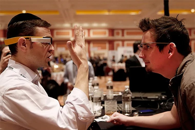 Lumus Ltd. exhibitor Ari Grobman (left) wears DK40 smart glasses while talking with Darren Kitchen wearing Google Glass glasses, not shown but seen everywhere, at the Consumer Electronics Show in Las Vegas.