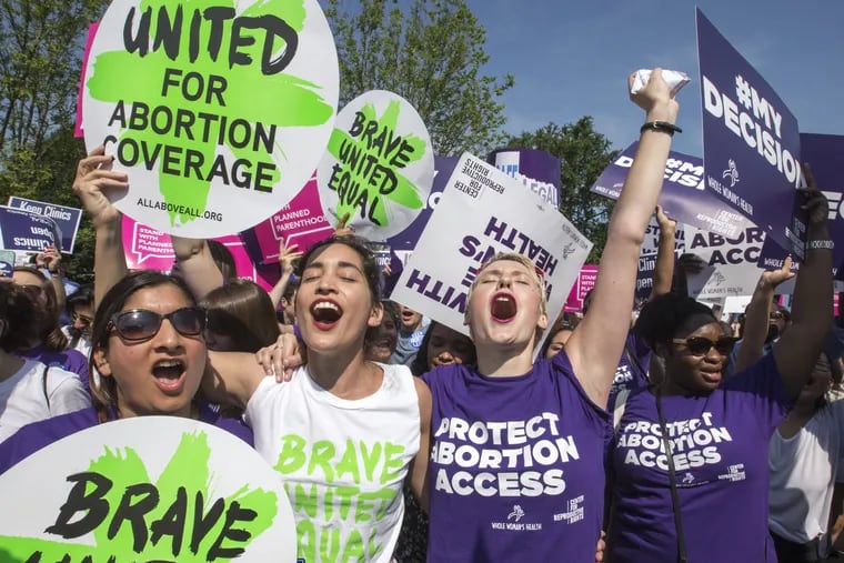Abortion rights activists, from left, Ravina Daphtary of Philadelphia, Morgan Hopkins of Boston, and Alison Turkos of New York City, rejoice in front of the Supreme Court in Washington, Monday, June 27, 2016, as the justices struck down the strict Texas anti-abortion restriction law known as HB2. 
