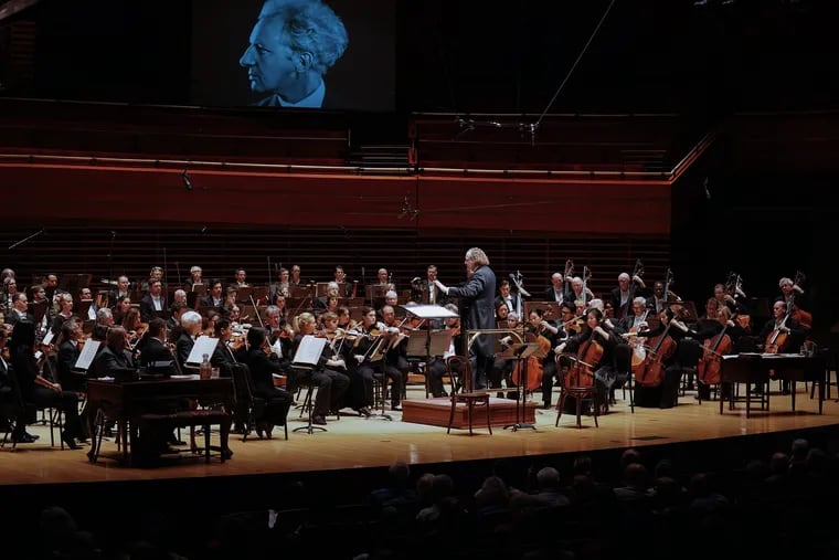 Philadelphia Orchestra principal guest conductor Stéphane Denève leading the Philadelphia Orchestra in the first of its Barnes/Stokowski Festival concerts Thursday night in Verizon Hall. An image of Stokowski is seen above the stage.