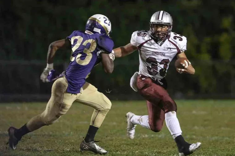 Conestoga's Corey Manning on his 9 yard run against Upper Darby's  Naiquan McKenzie during the 1st quarter in Upper Darby, Friday, October 9, 2015.