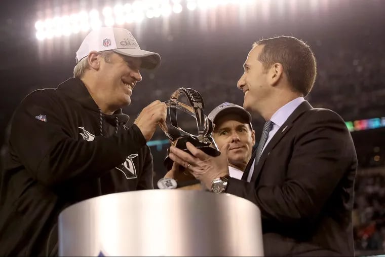 Eagles coach Doug Pederson, left, and Howie Roseman, right, holding the NFC Championship trophy after the Philadelphia Eagles win 38-7 over the Minnesota Vikings to win the NFC Championship game in Philadelphia, PA on January 21, 2018. DAVID MAIALETTI / Staff Photographer