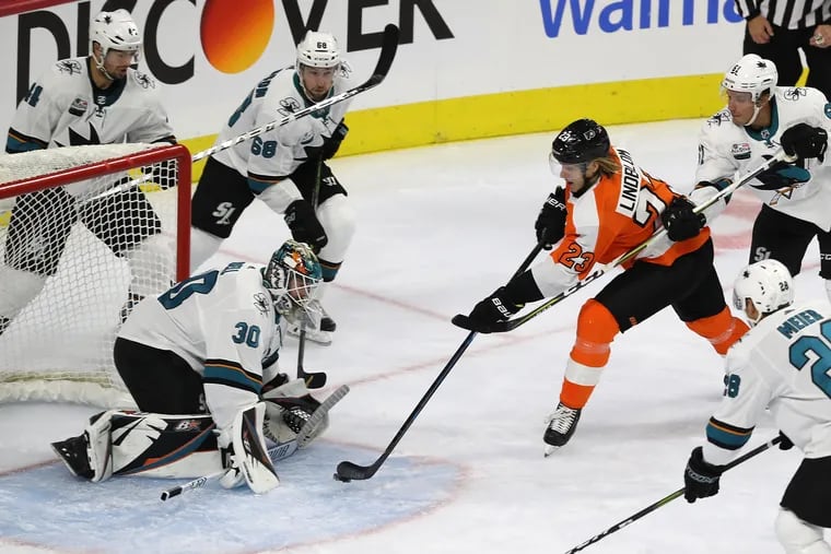 Oskar Lindblom, center, of the Flyers shoots but does not score against Aaron Dell of the Sharks during the 1st period. The Flyers take the ice in their home opener against the Sharks on Oct. 9, 2018.    CHARLES FOX / Staff Photographer
