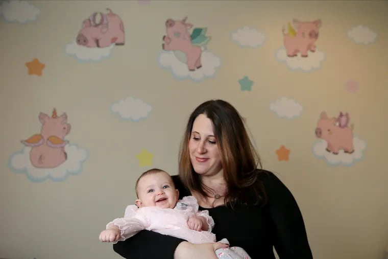 Lisa Treilman holds her daughter, Shoshana, 6 months, at their home in Philadelphia. Shoshana underwent a frenotomy to snip a tongue tie when she was 2 months old.