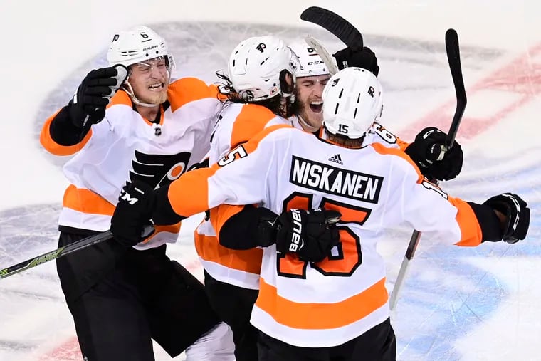 Flyers defenseman Ivan Provorov (center) celebrates his winning goal against the New York Islanders with some teammates.