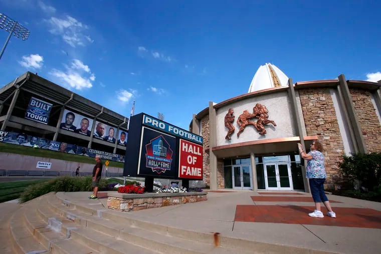 In this Aug. 7, 2015, file photo, a visitor to the Pro Football Hall of Fame pauses to take a photo of the sign in front in Canton, Ohio. The NFL has canceled the Hall of Fame game that traditionally opens the preseason and is delaying the 2020 induction ceremonies because of the coronavirus pandemic, two people with direct knowledge of the decision told The Associated Press on Thursday.