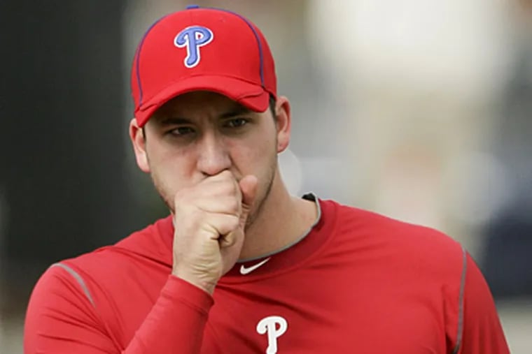 Phillies' minor league pitcher Phillippe Aumont blows on his hands during workouts in Clearwater on Tuesday. (Yong Kim / Staff Photographer)