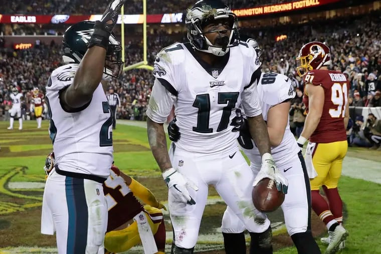 Eagles wide receiver Alshon Jeffery holds the football after scoring a touchdown with teammates running back Wendell Smallwood (left) and tight end Dallas Goedert against Washington on Sunday, December 30, 2018 in Landover, MD.