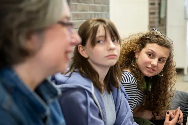 Sasha Mannino (center) and Iris Peron-Ames (right), both 15, look on as Kathryn Gay speaks with them Greenfield Elementary School on Tuesday. Graduates of Greenfield, Mannino and Peron-Ames now attend Science Leadership Academy and are running their second campaign to collect tampons and other toiletries for young people in need.