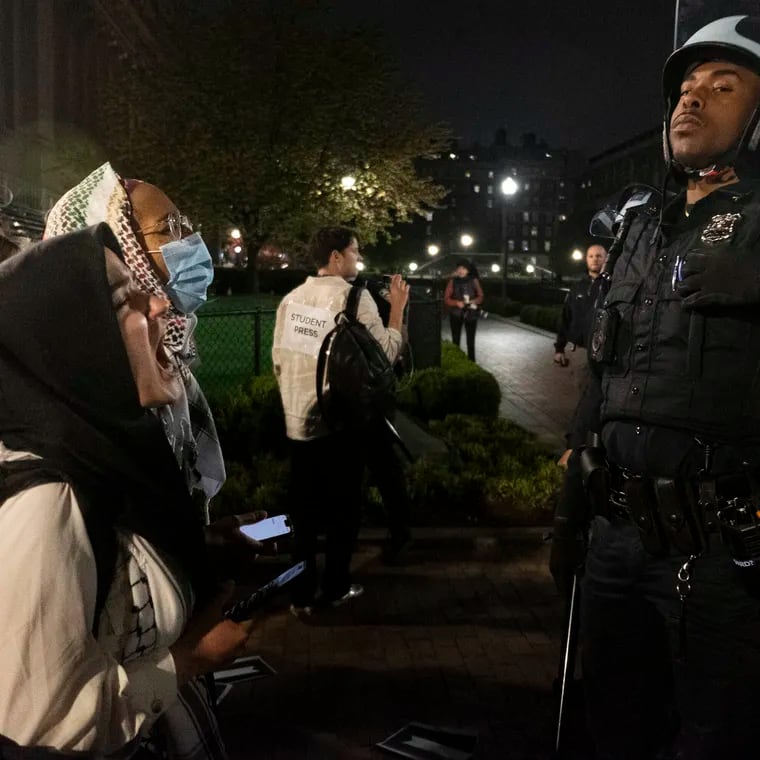 Pro-Palestinian student activists face off with New York Police Department officers during a raid on Columbia University's campus on Tuesday. Police arrested about 100 people as they dismantled encampments and removed people occupying Hamilton Hall.