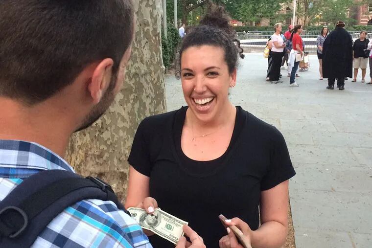Ashley Cafferty received a $100 bill for arriving 4 minutes and 55 seconds after the image was posted. ( Stu Bykofsky / DAILY NEWS )