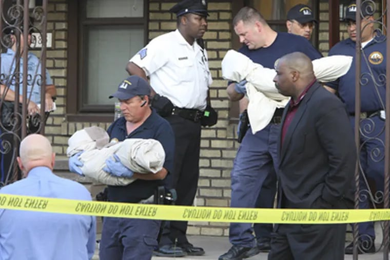 Police remove the bodies of twin toddlers on the 6300 block of Ditman Street in Northeast Philadelphia on Thursday. (Steven M. Falk / Staff Photographer)