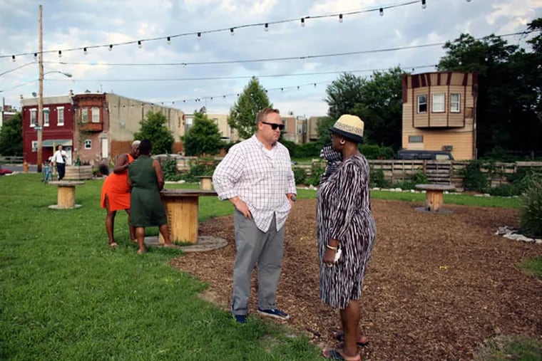 Pop-Up owner John Longacre with neighbor Florence Dixon at the beer garden in Point Breeze. Longacre is in compliance with the law, so what’s with the L&I infractions? (JOSEPH KACZMAREK / FOR THE DAILY NEWS)
