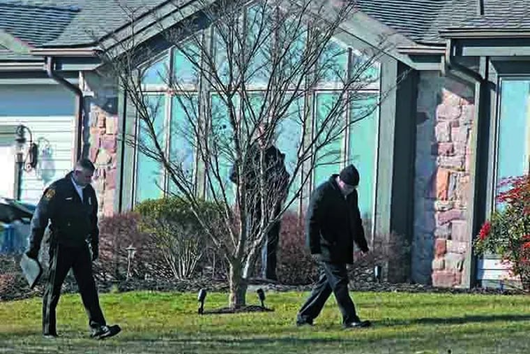 Bucks County law enforcement officers walk across the front yard of the house at 321 Swartley in Hilltown, Pa,, looking for clues in a home invasion that left one man dead in Jan. 2013. ( MICHAEL BRYANT / Staff Photographer/File )