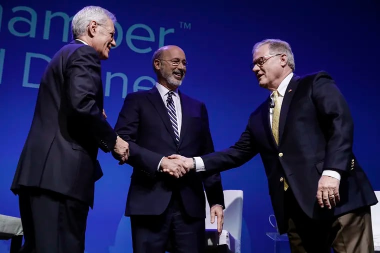 Democratic Gov. Tom Wolf, center, and Republican Scott Wagner, right, shake hands as moderator Alex Trebek looks on at a gubernatorial debate in Hershey, Pa., Monday, Oct. 1, 2018.