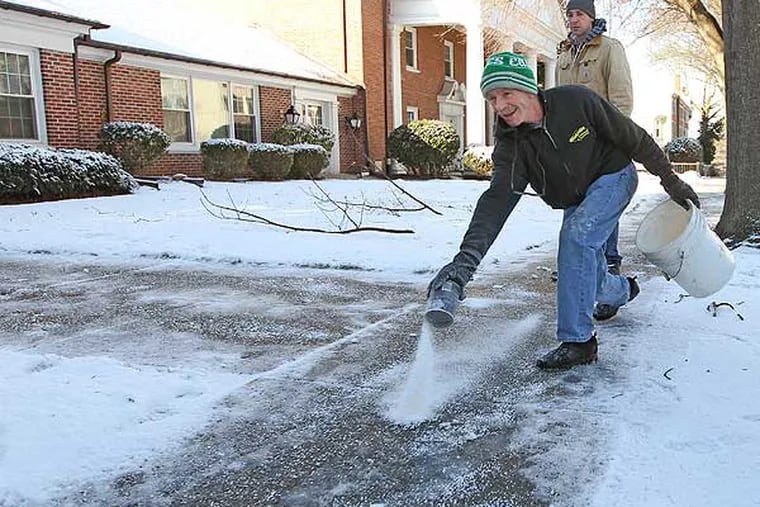 Chris McArdle, of McCardle Landscaping, looks like he is bowling in February 2013 as he spreads salt on the sidewalk of the First United Methodist Church of Media, Pa. (Michael Bryant / Staff Photographer)