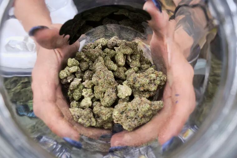 FILE - In this April 21, 2018, file photo a bud tender displays a jar of cannabis at the High Times 420 SoCal Cannabis Cup in San Bernardino, Calif. Businesses inside and outside the multibillion-dollar cannabis industry are using April 20, or “420,” to roll out marketing and social media messaging aimed at connecting with marijuana enthusiasts. (AP Photo/Richard Vogel, File)