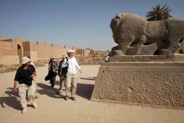 Members of a team from the World Monuments Fund and State Department gaze at a sculpted lion during their visit to the site.