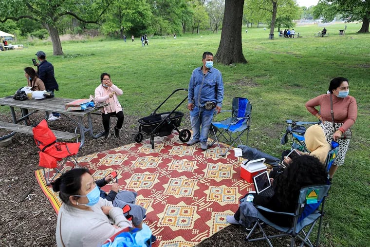 The Iv family, of North Philadelphia, stakes out a picnic spot around the Southeast Asian Market at FDR Park in May 2021.