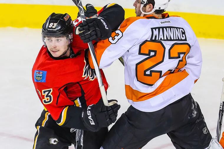 Calgary Flames center Sam Bennett (93) and Philadelphia Flyers defenseman Brandon Manning (23) fight for position during the second period at Scotiabank Saddledome.