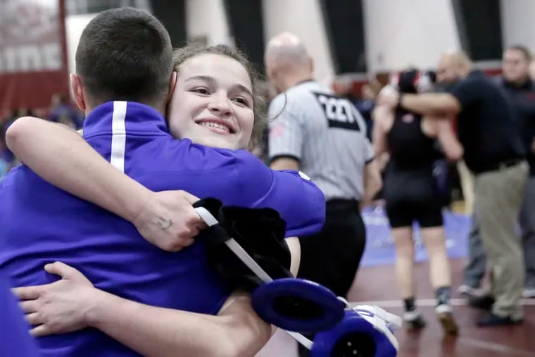 Williamstown’s Paige Colucci hugs a coach after pinning Kingsway’s Olivia Heyer (far right) for the 147-pound title.