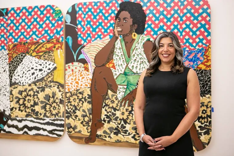 Penn professor Gwendolyn DuBois Shaw curated "30 Americans" for the Barnes Foundation, where it opens Sunday. Behind her is the work "Baby I Am Ready Now" by Mickalene Thomas.