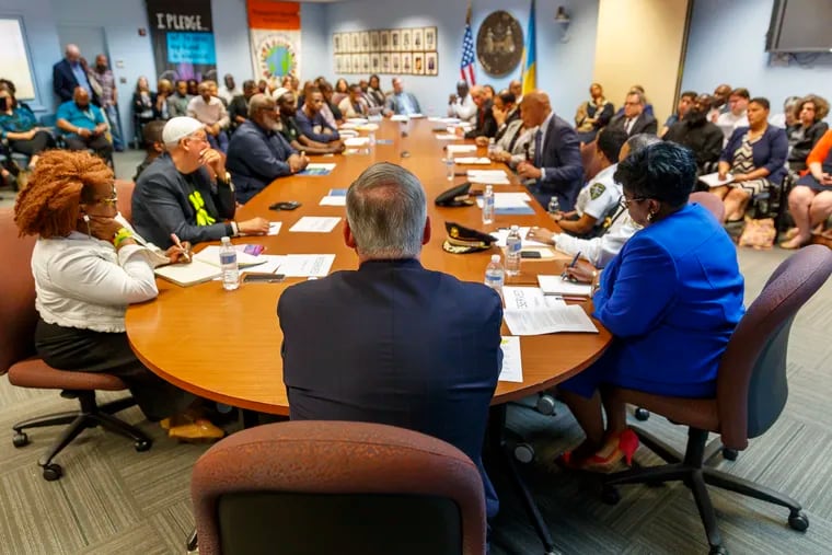 Mayor Jim Kenney (center with back to camera) looks down the long table of city officials (right) and community advocates (left) who were in the Municipal Services Building on May 7, 2019, to review and discuss the first three months of the Philadelphia Roadmap to Safer Communities, a five-year comprehensive action plan unveiled in January to address the increasing gun violence in neighborhoods across the city.