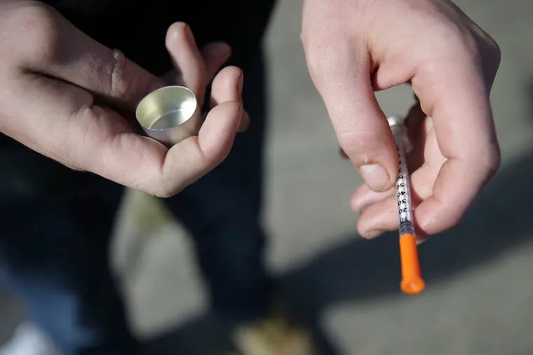 In this Oct. 22, 2018 file photo, a fentanyl user holds a needle near Kensington and Cambria in Philadelphia.