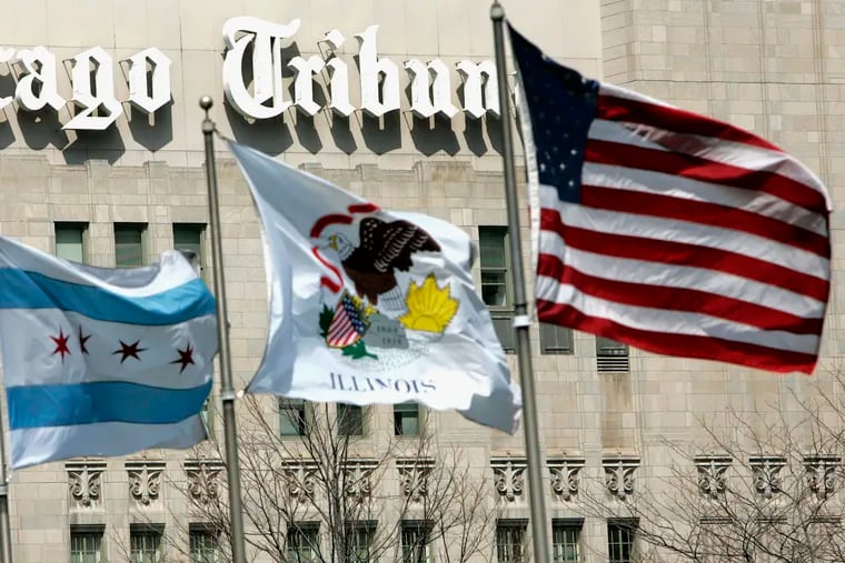 Flags wave near the Chicago Tribune Tower in downtown Chicago. Newspaper publisher Tribune has agreed to be sold to Alden Global Capital, a hedge fund known for cutting costs and eliminating newsroom jobs, in a deal valued at $630 million.