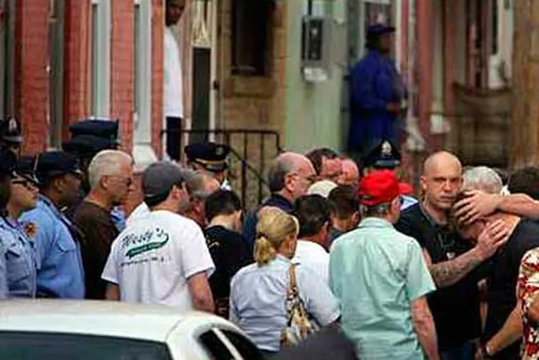 Family, friends and colleagues of slain Philadelphia Police Officer Patrick McDonald gathered Wednesday at  the scene of the shooting, the 2200 block of Colorado Street in North Philadelphia. (David Maialetti / Philadelphia Daily News)