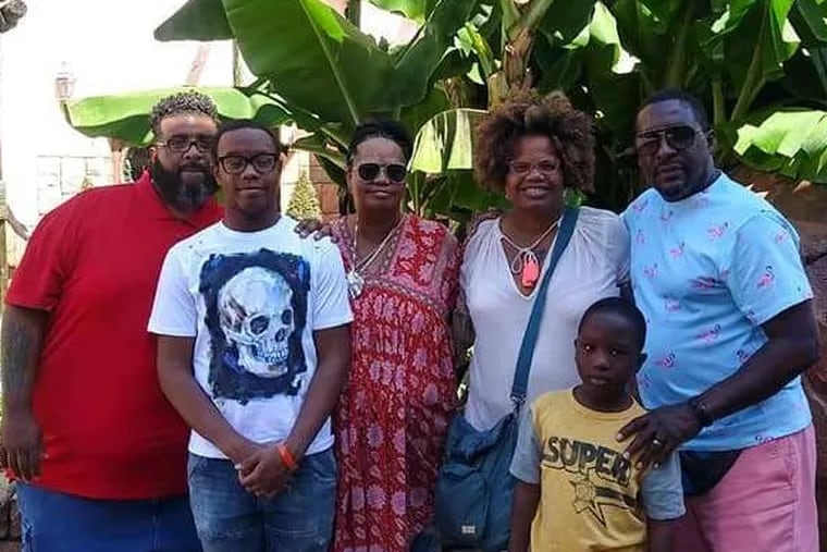 Janet Woodson (fourth from left) and her family are shown during a recent visit to Walt Disney World, from which they returned Oct. 13. Two weeks later, Woodson's son Maurice Louis allegedly shot and killed Woodson; her sons Sy-eed Woodson (second from left) and Leslie Woodson-Holmes (second from right); and her husband, Leslie Holmes (far right). Also shown are Janet Woodson's sister Valerie Pini (third from left) and her husband, John Pini (left).
