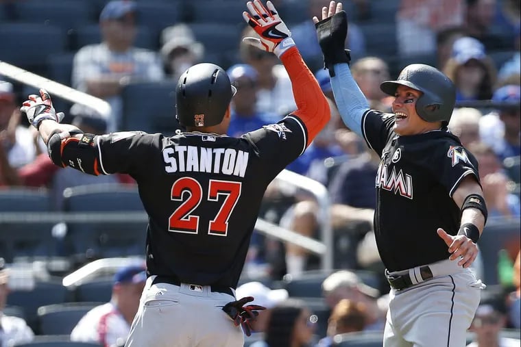 The Marlins' Giancarlo Stanton (27) is congratulated by Miguel Rojas (19) after he hit a three-run home run against the New York Mets on Sunday.