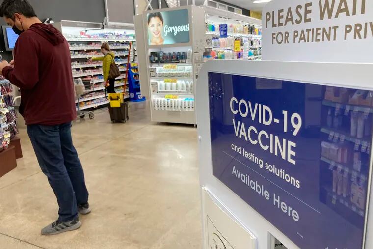 A patient waits to be called for a COVID-19 vaccination booster shot outside a pharmacy in a grocery store in Denver.