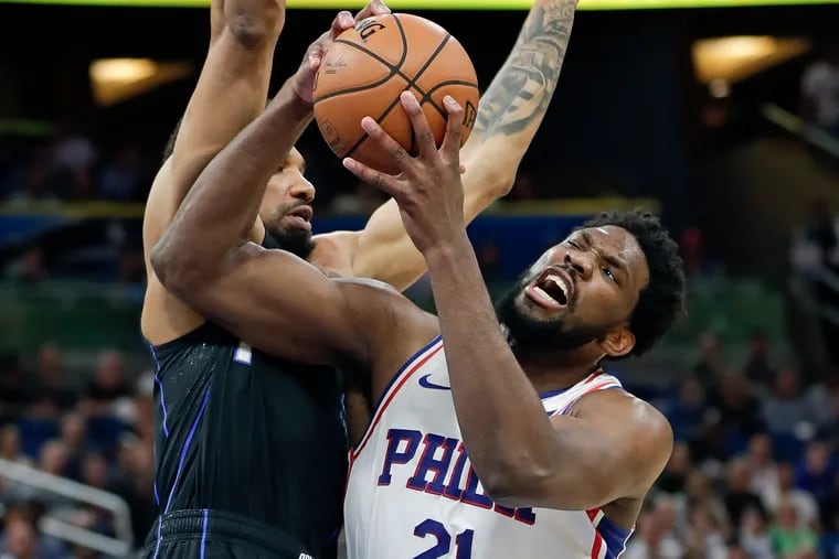 Philadelphia 76ers' Joel Embiid (21) is fouled as he collides with Orlando Magic's Khem Birch while going up to shoot during the first half of an NBA basketball game, Monday, March 25, 2019, in Orlando, Fla. (AP Photo/John Raoux)