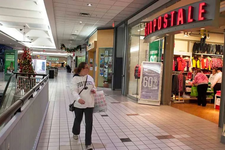 Black Friday shopper Christina Paytas, of Broomall walks past near empty shops in 2012 at the Granite Run Mall in Media Pa. (ED HILLE / Staff Photographer)