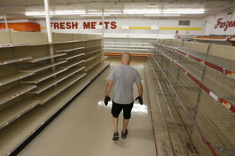 Store owner Jim McCouch walks down an empty aisle in his store, Perk’s Family Market in Pine Hill, on one of the supermarket's last days in business.