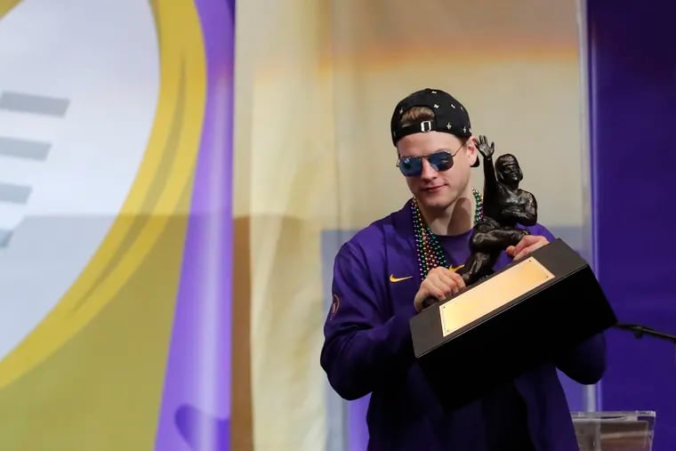 Quarterback Joe Burrow, with his cap on backward, just like Carson Wentz, holds the Heisman Trophy in January. He and Wentz meet up on Sunday when the Eagles host the Bengals.
