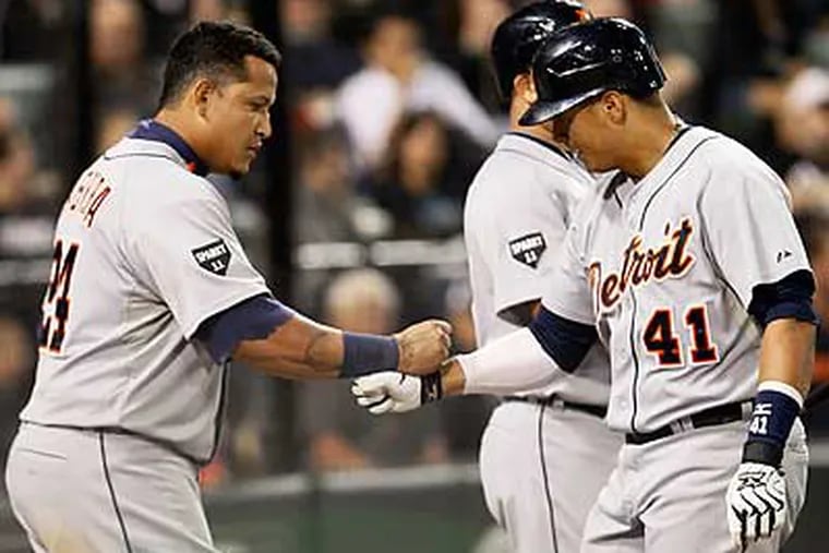 Victor Martinez (41) and Miguel Cabrera celebrate with Will Rhymes after scoring onMartinez's three-run home run in the sixth inning. (Charles Rex Arbogast/AP)